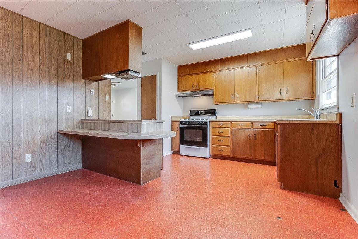 2801 62nd Street Lubbock, TX 79413 - Photo 12 of 21 a kitchen with stainless steel appliances granite countertop a stove top oven a sink dishwasher and a fireplace with wooden floor
