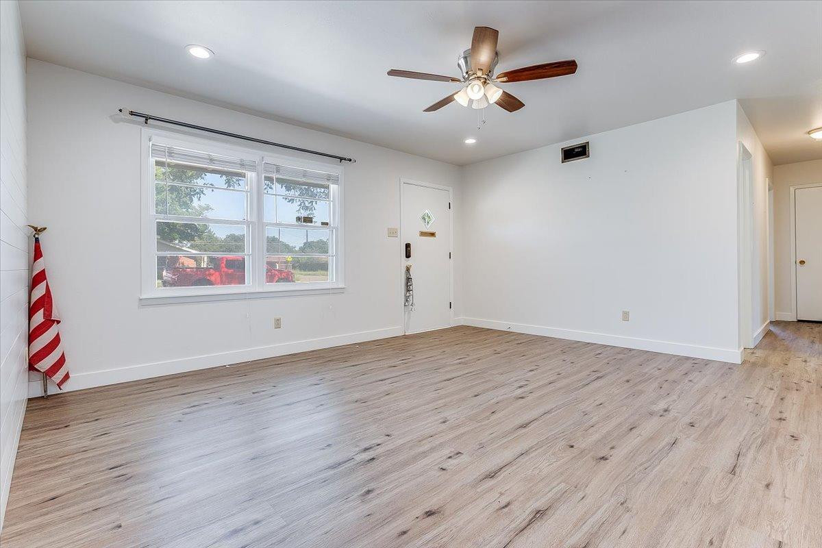 2801 62nd Street Lubbock, TX 79413 - Photo 9 of 21 an empty room with wooden floor and windows