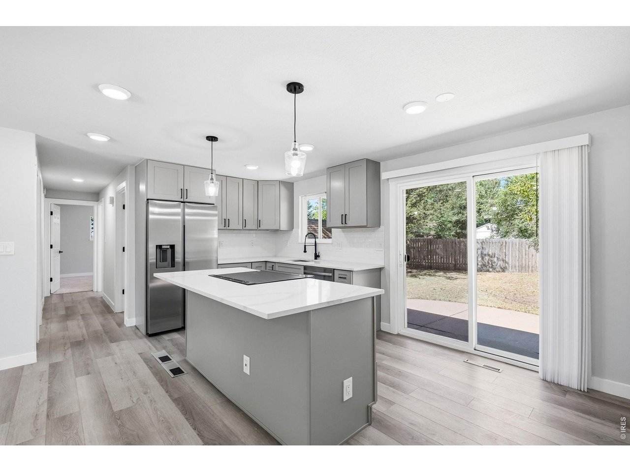 1035 6th Street Berthoud, CO 80513 - Photo 14 of 37 a kitchen with kitchen island a sink stainless steel appliances and cabinets