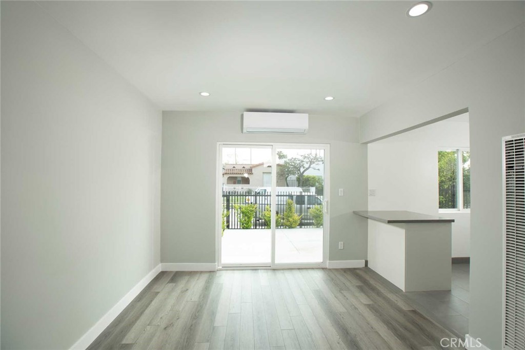 5459 Carlin Street, Unit 1 Los Angeles, CA 90016 - Photo 14 of 22 an empty room with wooden floor and windows