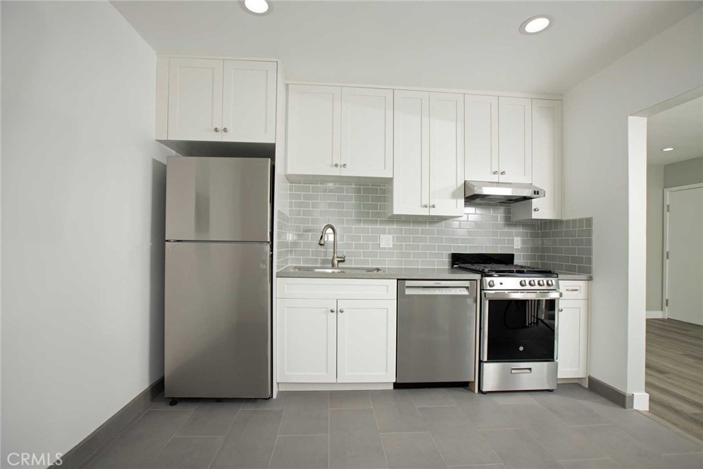 5459 Carlin Street, Unit 1 Los Angeles, CA 90016 - Photo 16 of 22 a kitchen with a white stove refrigerator and cabinets