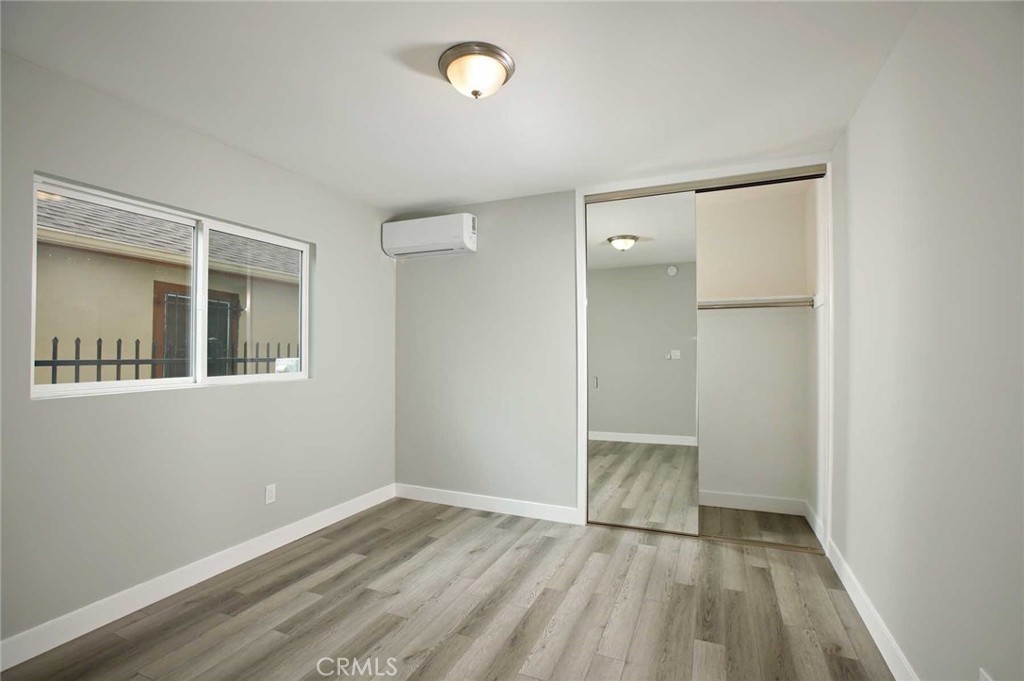 5459 Carlin Street, Unit 1 Los Angeles, CA 90016 - Photo 21 of 22 an empty room with wooden floor and a window