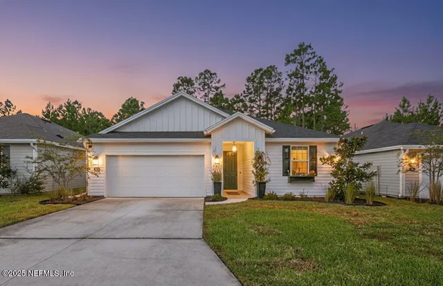 a front view of a house with a garden and yard