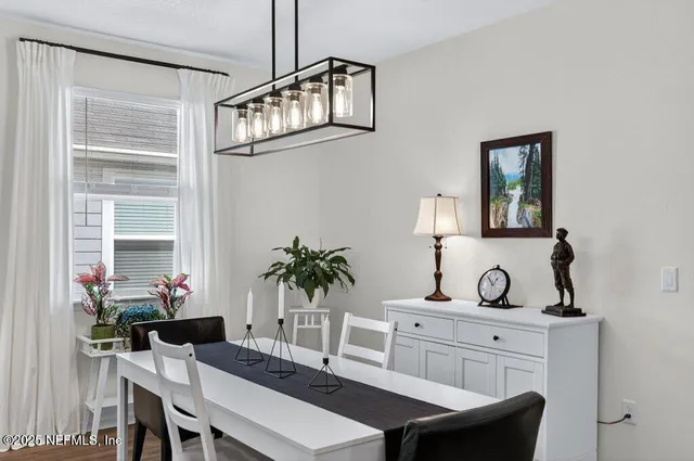a kitchen with stainless steel appliances kitchen island granite countertop a table chairs and white cabinets