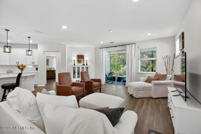 a kitchen with stainless steel appliances white cabinets and a stove a refrigerator with wooden floor