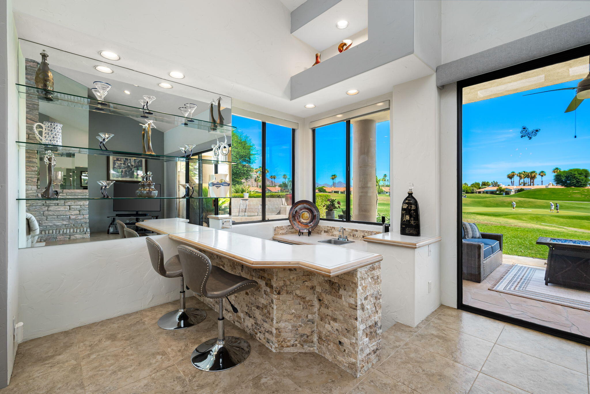 80449 Pebble Beach La Quinta, CA 92253 - Photo 37 of 60 a dining hall with stainless steel appliances kitchen island granite countertop a table chairs and a sink