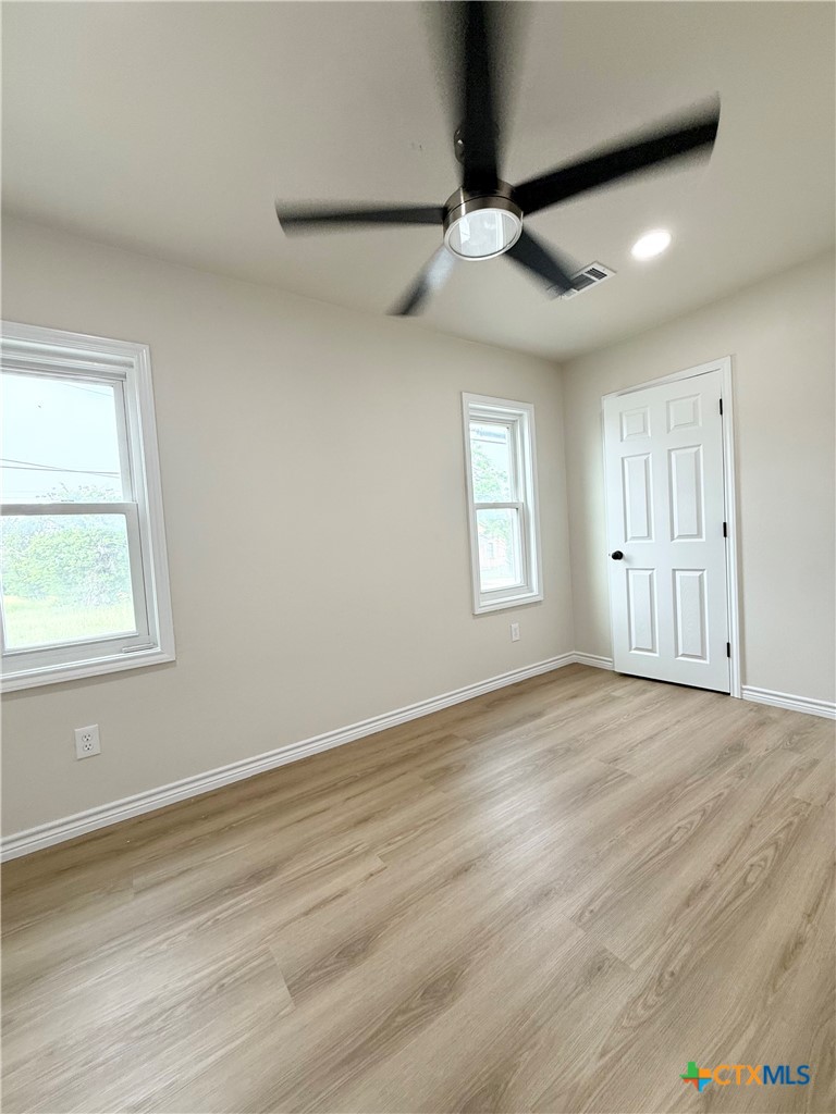 421 South 32nd Street Temple, TX 76501 - Photo 18 of 27 an empty room with wooden floor fan and windows