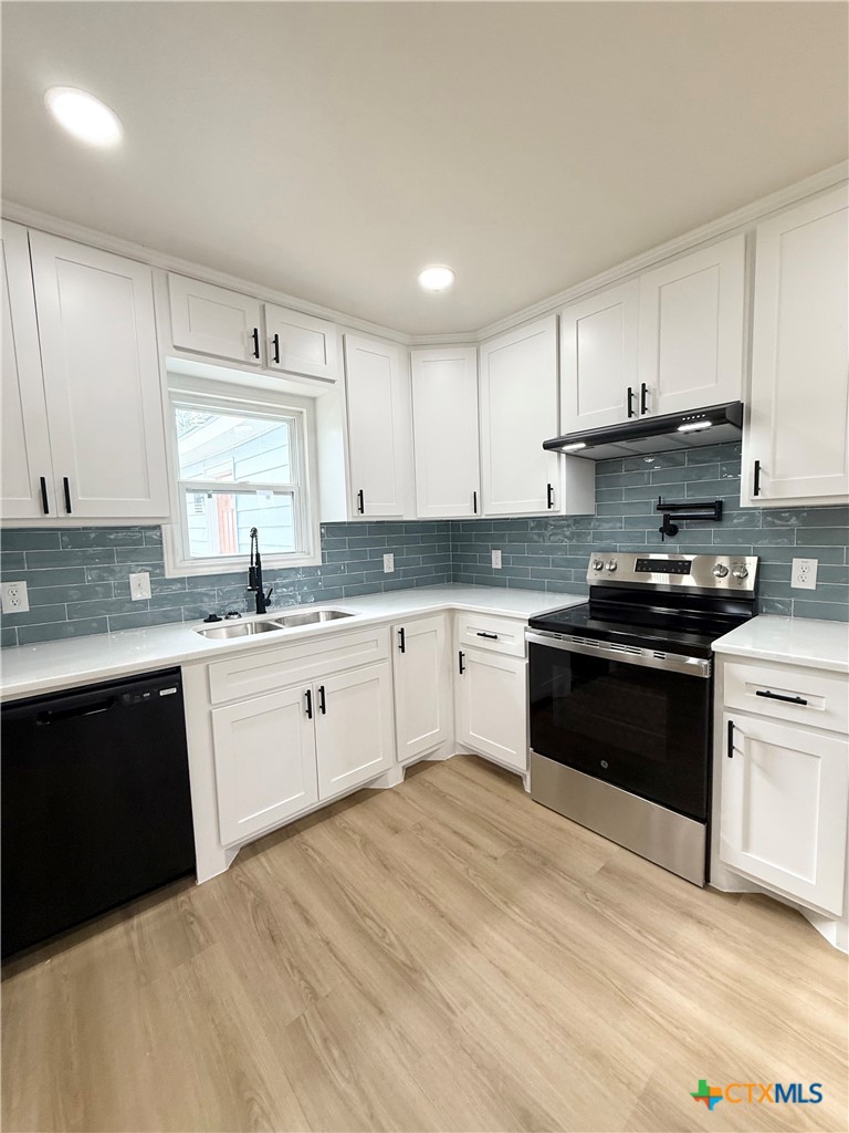 421 South 32nd Street Temple, TX 76501 - Photo 8 of 27 a kitchen with granite countertop a sink cabinets and stainless steel appliances