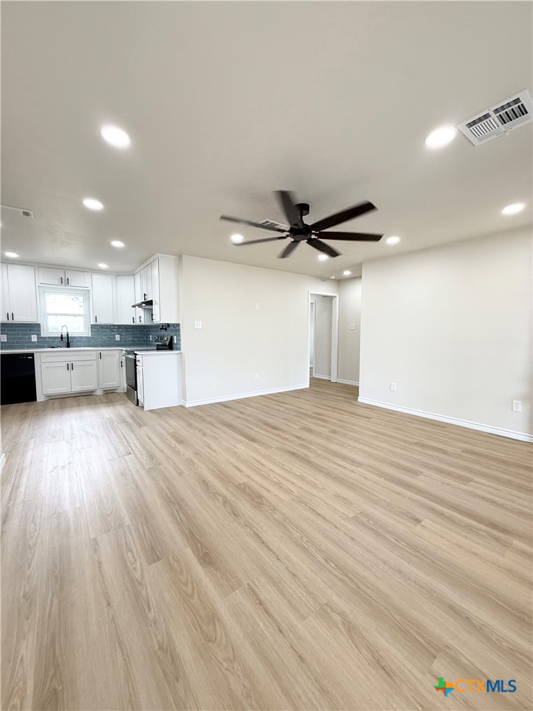 421 South 32nd Street Temple, TX 76501 - Photo 9 of 27 a view of a kitchen with a wooden floor and a ceiling fan