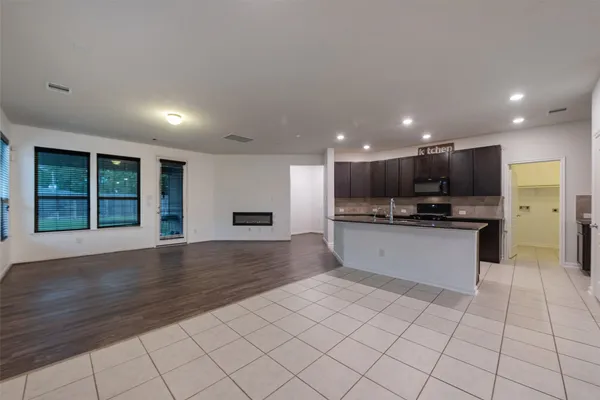 a kitchen with stainless steel appliances kitchen island granite countertop a refrigerator and a sink