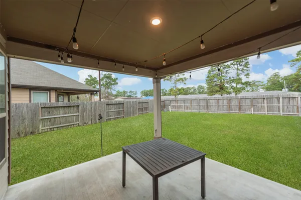 a view of a backyard with table and chairs under an umbrella