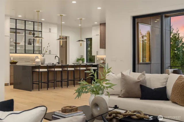 a living room with furniture kitchen view and a large window