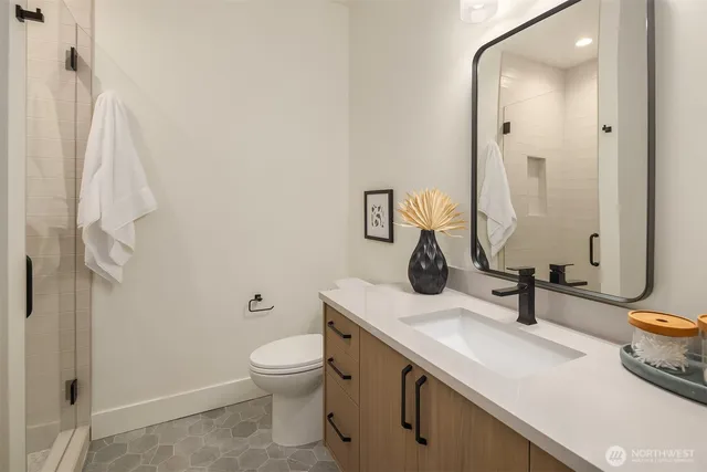 a bathroom with a sink a toilet and shower