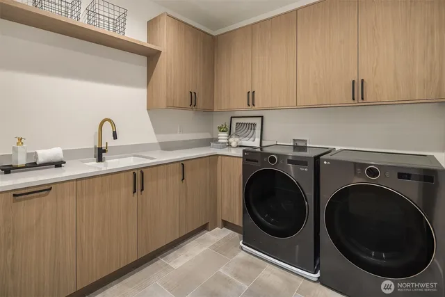 a utility room with sink dryer and washer