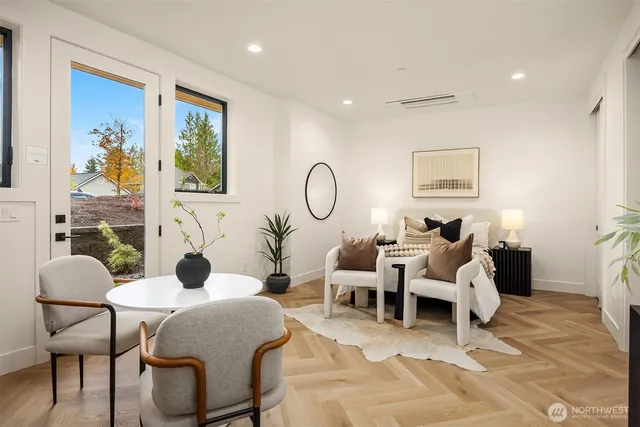 a living room with furniture potted plant and a large window