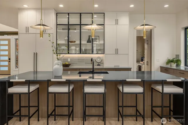 a kitchen with stainless steel appliances kitchen island granite countertop a table and chairs