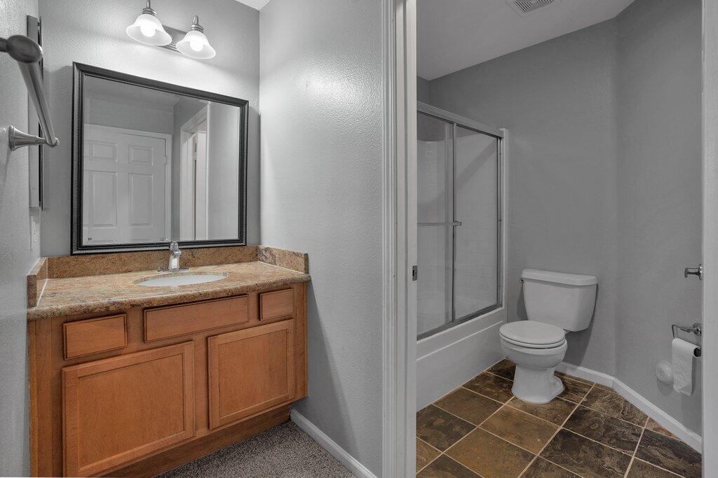 375 Central Avenue, Unit 10 Riverside, CA 92507 - Photo 11 of 33 a bathroom with a granite countertop toilet a sink and a mirror