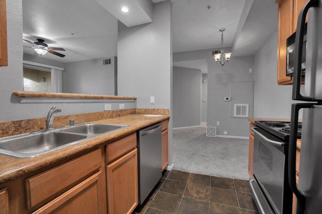 375 Central Avenue, Unit 10 Riverside, CA 92507 - Photo 6 of 33 a kitchen with stainless steel appliances granite countertop a sink stove and refrigerator