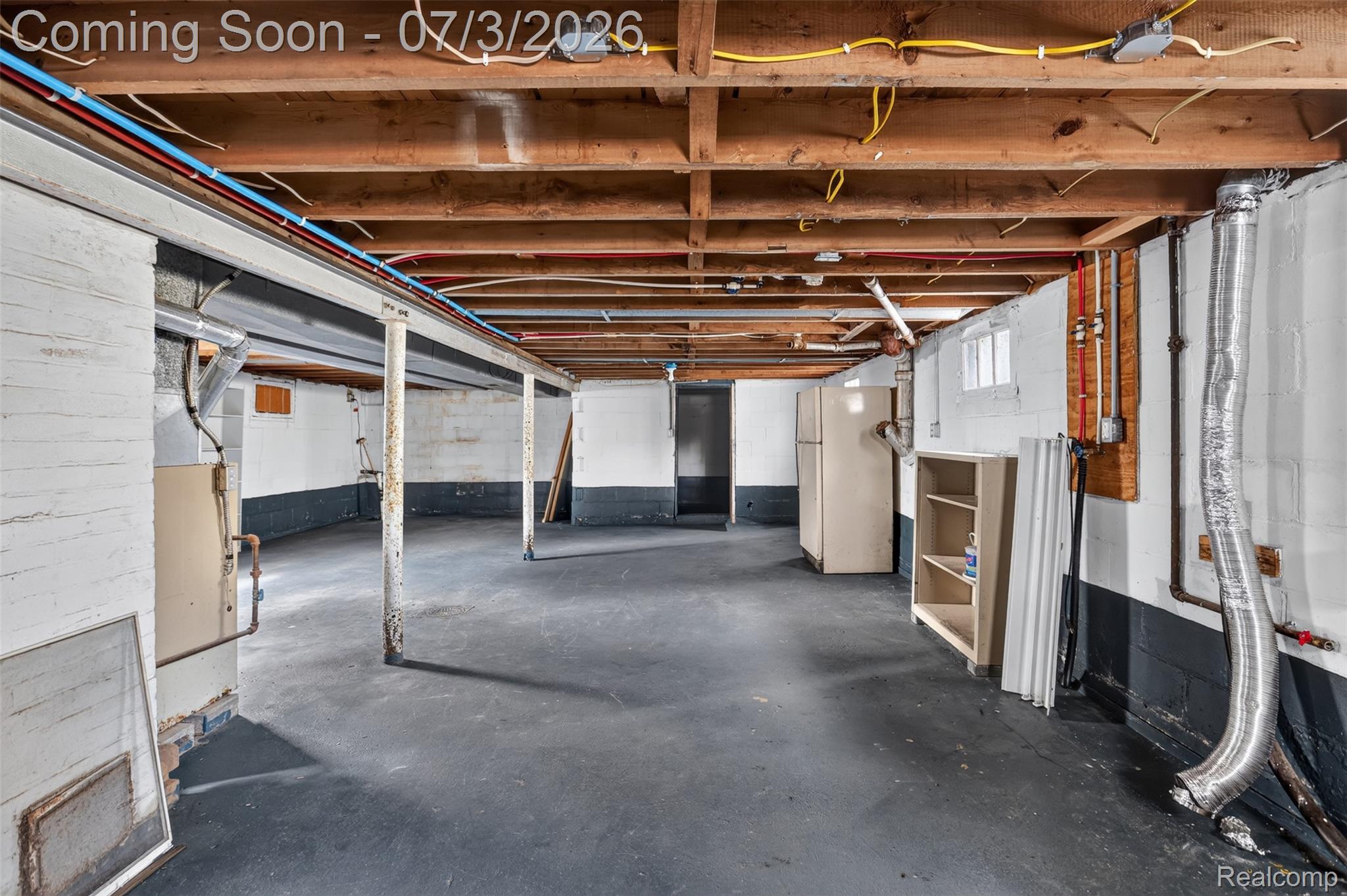 4322 Baker Road Bridgeport, MI 48722 - Photo 19 of 29 Spacious unfinished basement featuring exposed ceiling joists, painted concrete block walls, and a concrete floor