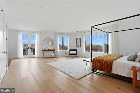 a spacious bedroom with a bed and large mirror with window