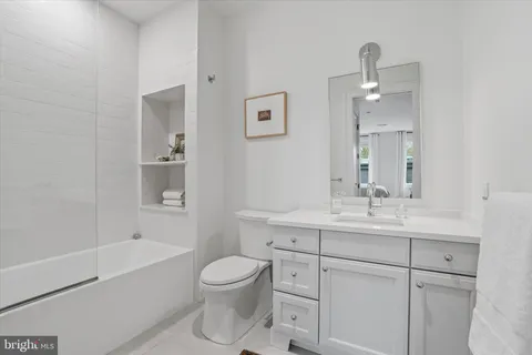 a bathroom with a toilet a sink a mirror and shower