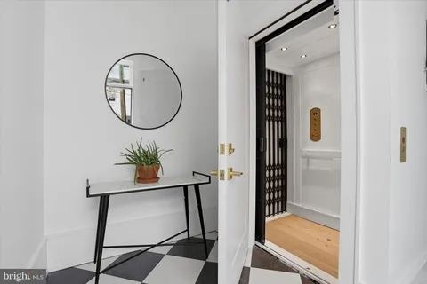 a room with painting on wall and a mirror