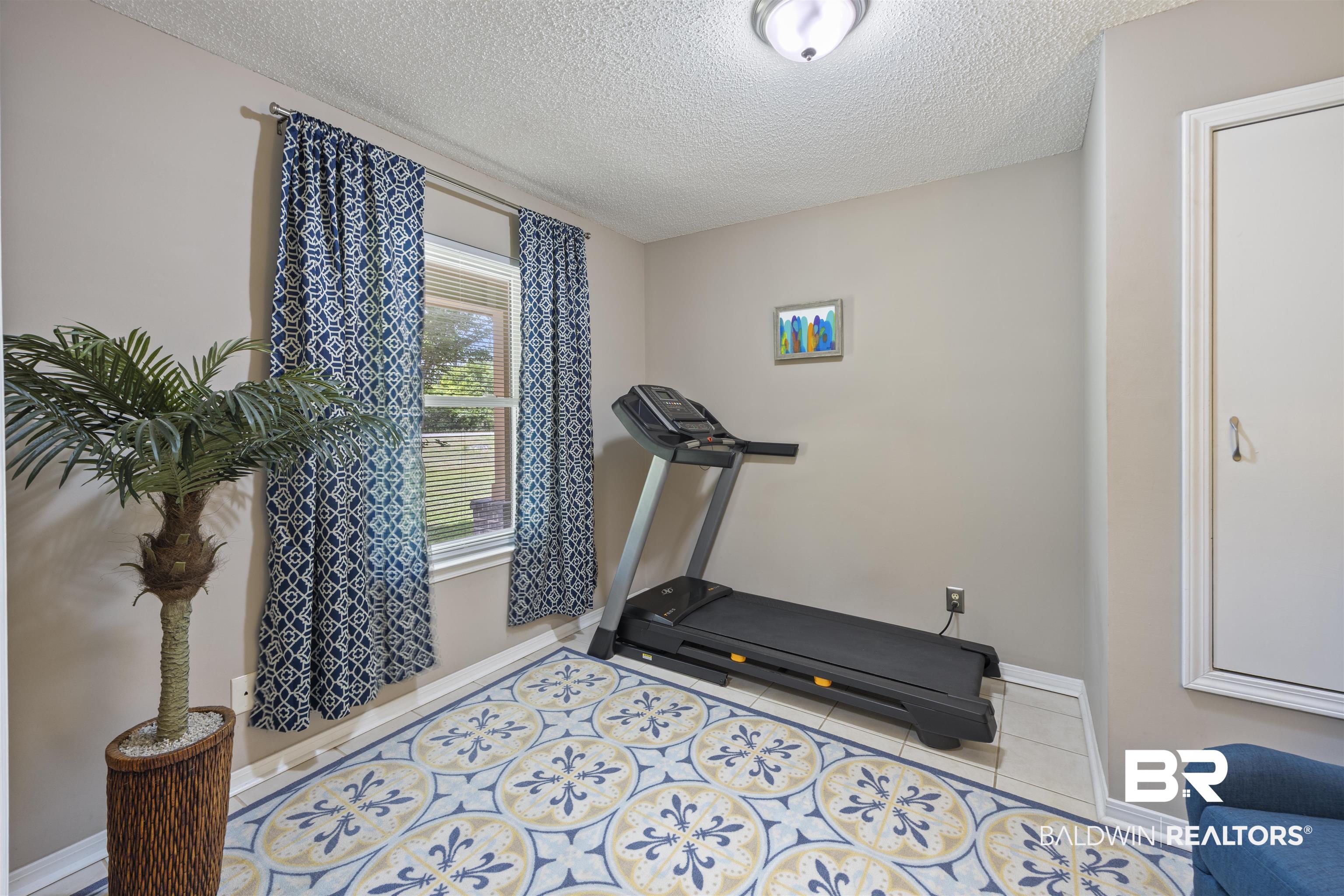 9771 Clarke Ridge Road Foley, AL 36535 - Photo 24 of 72 Workout room with tile patterned floors, a textured ceiling, and baseboards