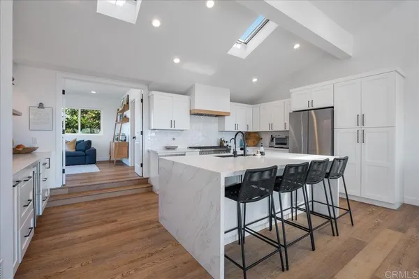 a kitchen with white cabinets appliances and a sink