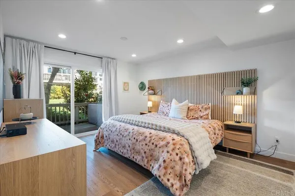 a large bedroom with a bed and a view of balcony