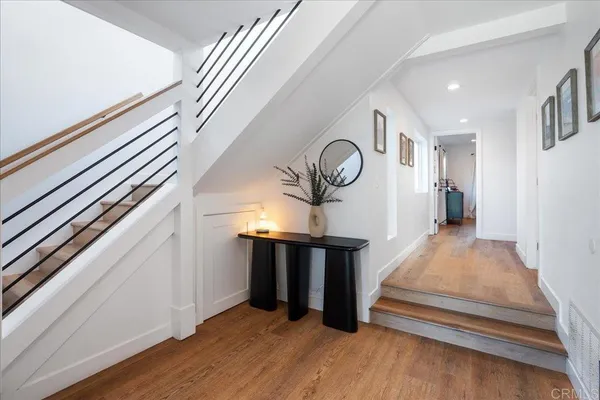 a view of a hallway with wooden floor and staircase