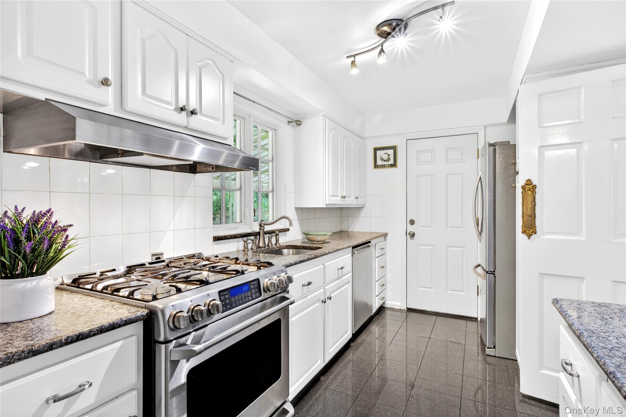 60 Mill Spring Road Manhasset, NY 11030 - Photo 7 of 18 a kitchen with a stove and white cabinets