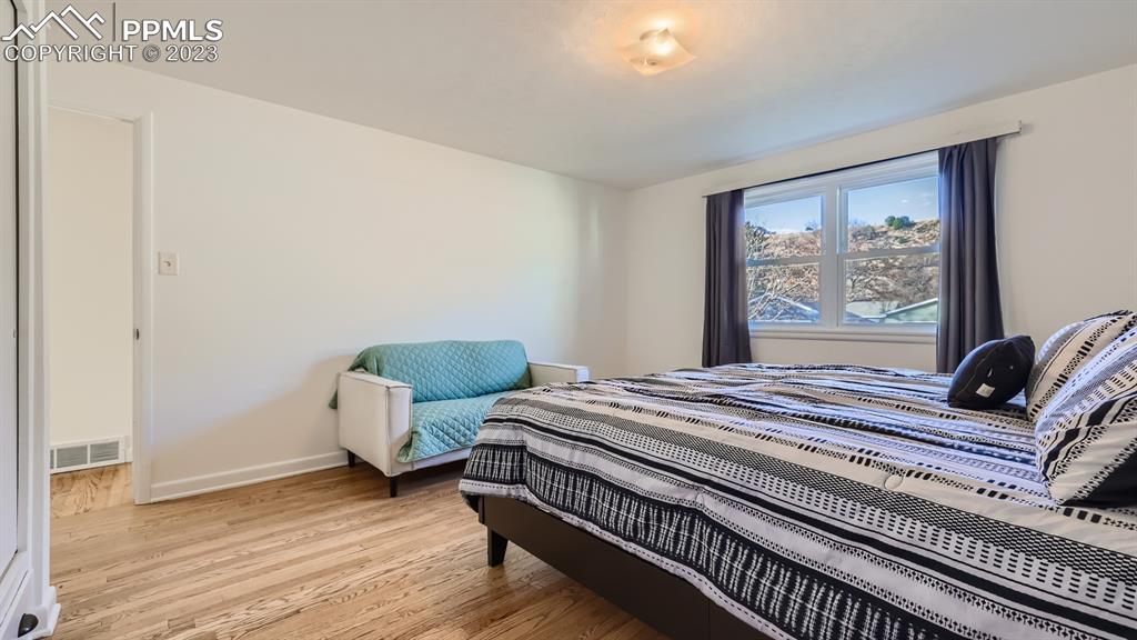 530 Valley Road Colorado Springs, CO 80904 - Photo 18 of 50 a bedroom with bed and wooden floor
