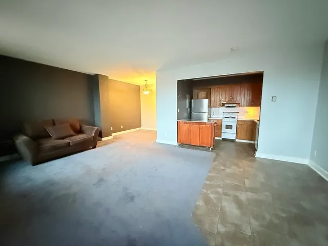 a living room with furniture and a kitchen area