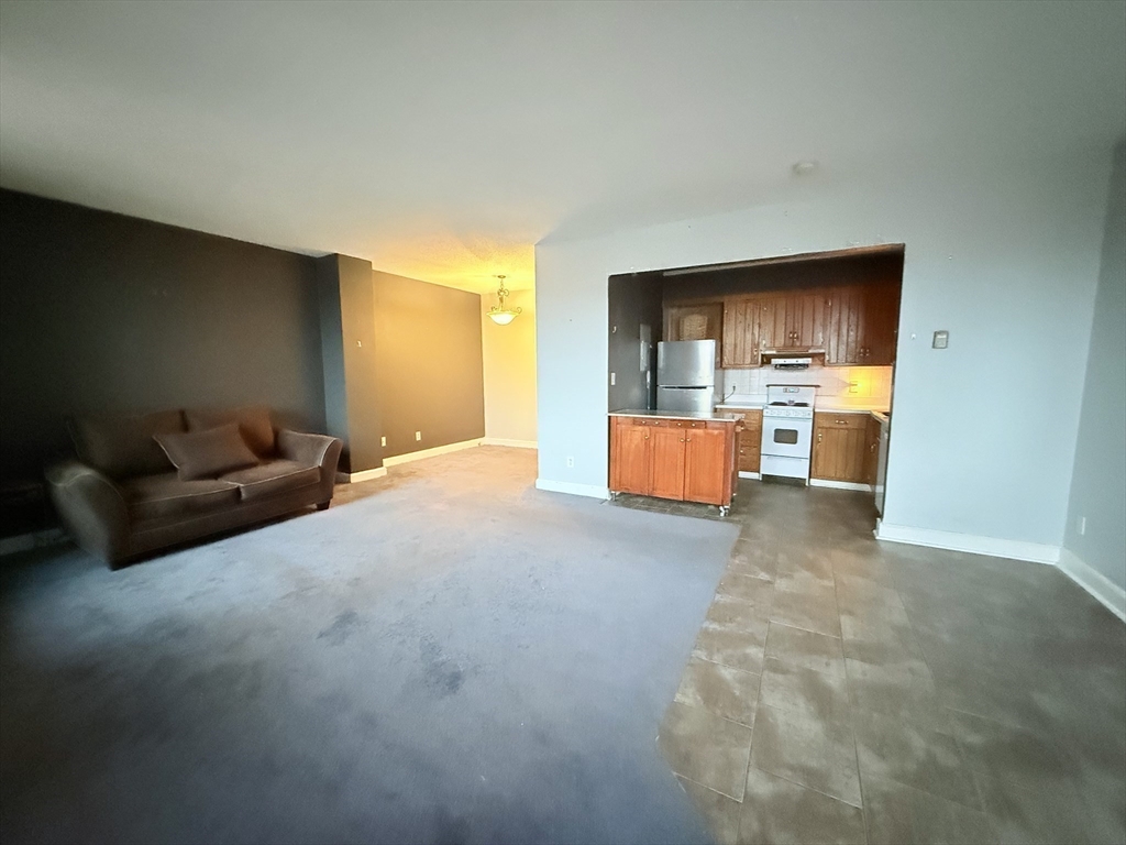 140 Chestnut Street, Unit 604 Springfield, MA 01103 - Photo 12 of 21 a living room with furniture and a kitchen area