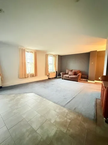 a large bedroom with a bed and window