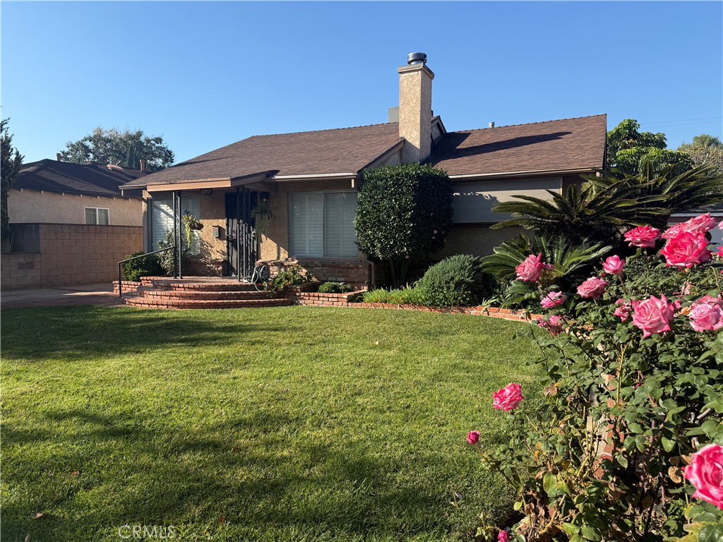 a front view of a house with a big yard and fountain
