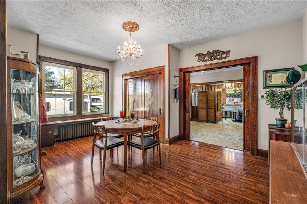 3475 Darlington Road Darlington, PA 16115 - Photo 4 of 17 a dining room with wooden floor a chandelier a wooden table and chairs