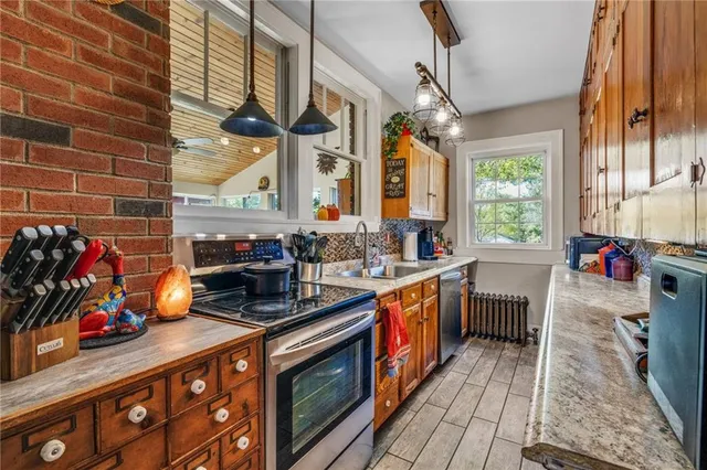 a kitchen with stainless steel appliances a sink stove and window