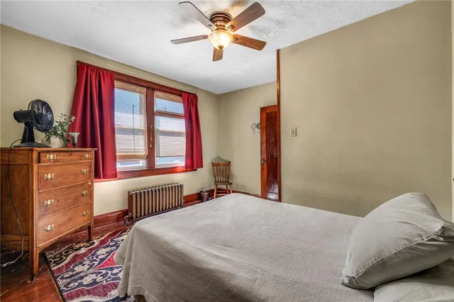 a bedroom with a bed and a dresser next to a window