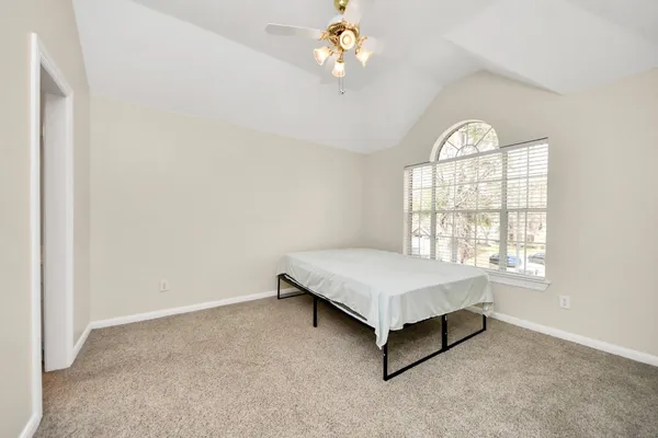 an empty room with windows and ceiling fan