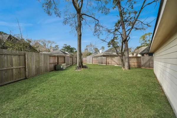 a view of a house with backyard and a tree