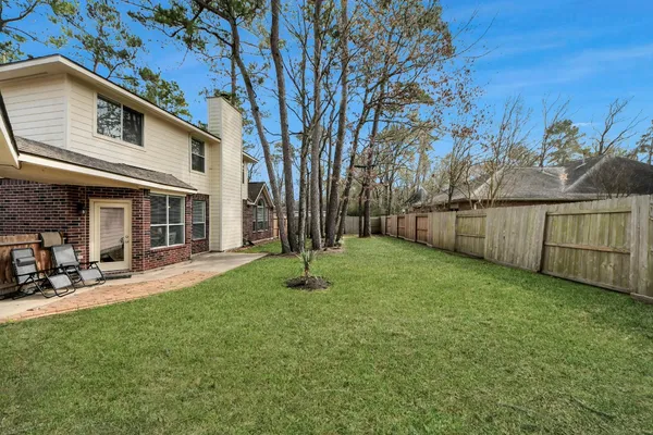 a view of a backyard with table and chairs and a large tree