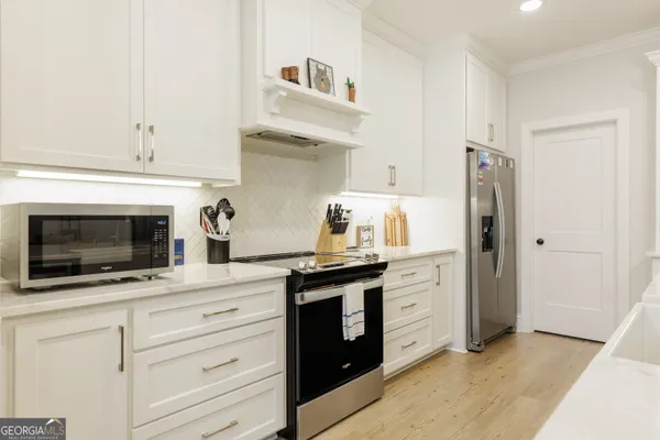 a kitchen with stainless steel appliances white cabinets and a refrigerator