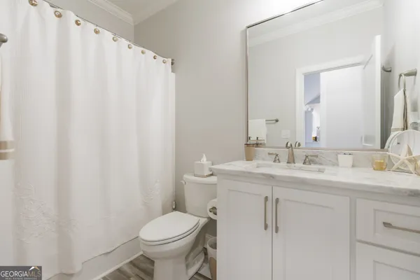 a spacious bathroom with a granite countertop sink a mirror and a shower