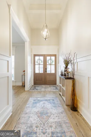 a living room with furniture kitchen view and a wooden floor