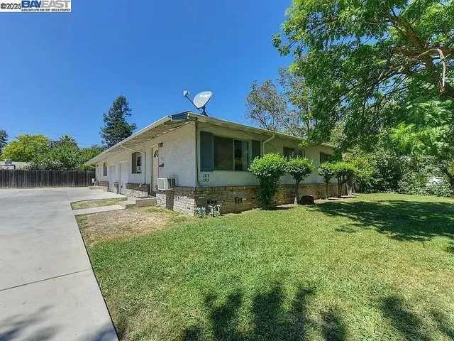 a view of a house with backyard and sitting area