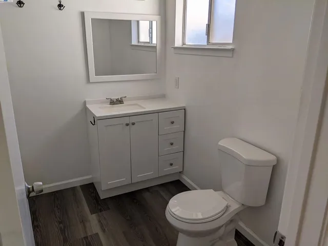 a bathroom with a granite countertop toilet and a sink