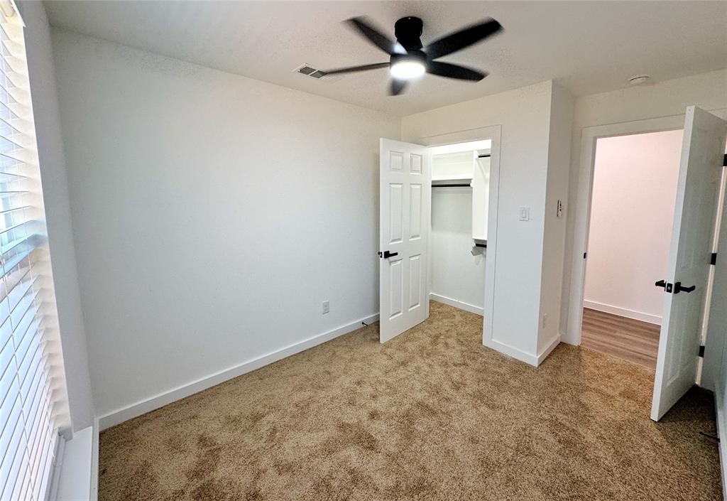 1811 Washington Street Commerce, TX 75428 - Photo 12 of 36 a view of a big room with wooden floor and a ceiling fan