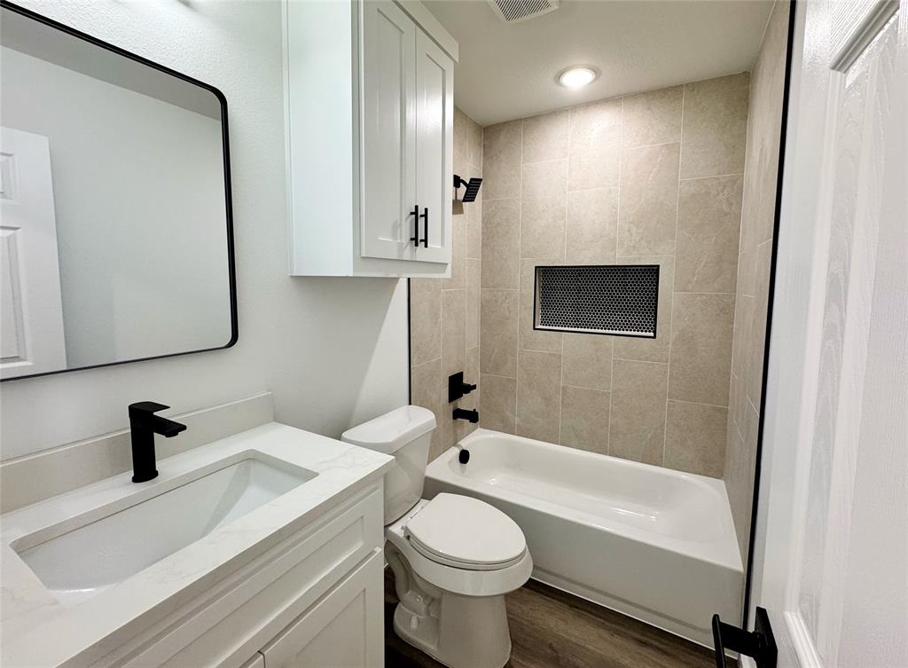 1811 Washington Street Commerce, TX 75428 - Photo 13 of 36 a bathroom with a sink a toilet and shower