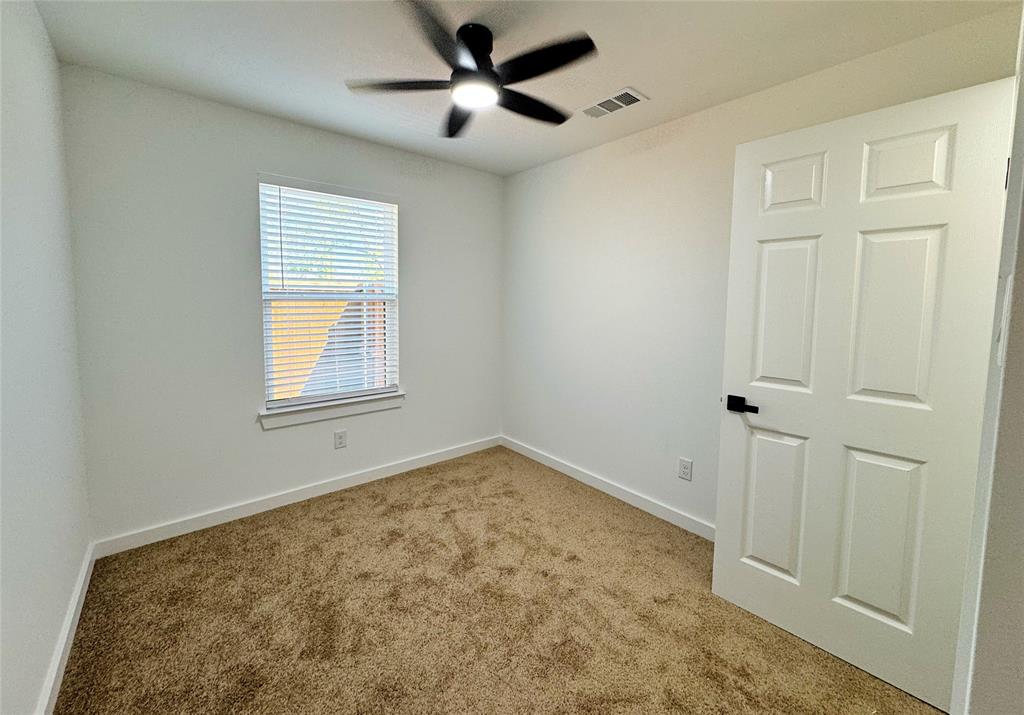 1811 Washington Street Commerce, TX 75428 - Photo 14 of 36 an empty room with a ceiling fan and window